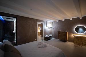 a bedroom with a bed and a vanity and a mirror at SantaTeresa19 Suite & Spa in Palermo