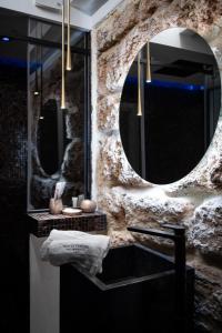 a bathroom with a stone wall and a mirror at SantaTeresa19 Suite & Spa in Palermo