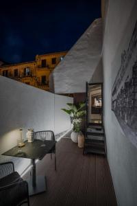 una terrazza in legno con tavolo e sedie su un edificio di SantaTeresa19 Suite & Spa a Palermo