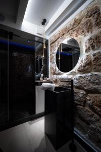 a bathroom with a stone wall and a mirror at SantaTeresa19 Suite & Spa in Palermo