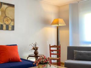 a living room with a blue couch and a lamp at El Jardín de la Morena - Casco Histórico - VUT LE 1205 in León