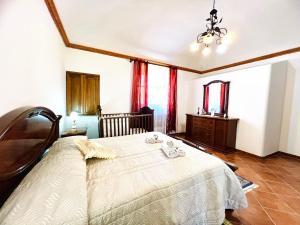 1 dormitorio con 1 cama blanca grande y cortinas rojas en Nonna Sasà, en Torretta