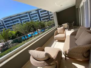 a balcony with couches and chairs and a view of a building at شقة فندقية عائلية بجانب المطار منتجع اوشن بلو in Cairo