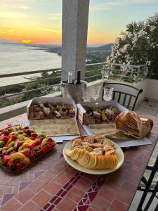 une table avec plusieurs assiettes de nourriture sur un balcon dans l'établissement Camera con uso piscina vista mare, à Terra Mala