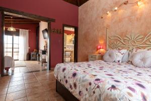 a bedroom with a large bed and red walls at Villa Maravilla piscina climatizada in Villaverde +67 photos