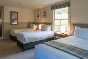 a hotel room with two beds and a window at Cardrona Hotel in Cardrona