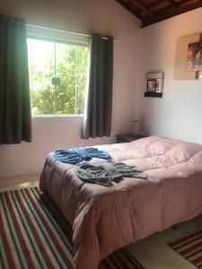 Schlafzimmer mit einem Bett, einem Fenster und einem Teppich in der Unterkunft Chalés lá na roça in Costas