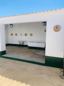 Habitación blanca con 2 bancos y mesa en Los Alcores , disfruta de la naturaleza !, en Villalba del Alcor