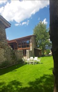 einen Hof mit weißen Stühlen und einem Gebäude in der Unterkunft Turisme Rural Ca l'Axai casa 3 in Pi