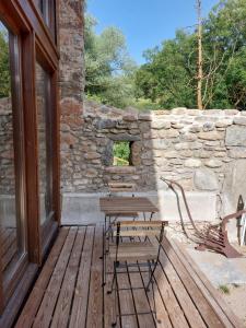 eine Holzterrasse mit einem Holztisch und einer Bank in der Unterkunft Turisme Rural Ca l'Axai casa 3 in Pi