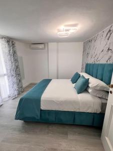 1 dormitorio con 1 cama grande con almohadas azules en Mezzo Experience Holiday Home Eur, en Roma