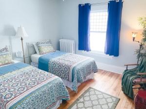 1 dormitorio con 2 camas y una ventana con cortinas azules en 4BR 2BA Home in Charming St Paul - Sleeps 10, en Saint Paul