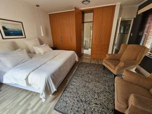 1 dormitorio con 1 cama grande y 2 sillas en Chez Paul Luxury House with Pool & Solar, en Johannesburgo