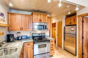 a kitchen with stainless steel appliances and wooden cabinets at Copperbottom Inn #310 in Park City