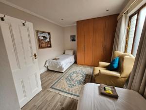 Habitación con 1 dormitorio con 1 cama y 1 silla en Chez Paul Luxury House with Pool & Solar, en Johannesburgo