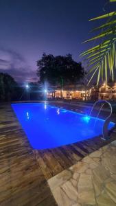 a large blue swimming pool at night at Pousada Real Cipo in Serra do Cipo