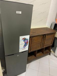 a refrigerator in a kitchen next to a wooden cabinet at Résidence 44 in Dakar