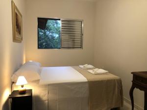 1 dormitorio con 1 cama blanca y ventana en Cabana com Vista para a Lagoa da Conceição RM9376, en Florianópolis