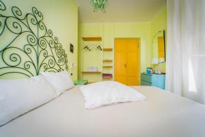 1 dormitorio con cama blanca y pared amarilla en La casa dei Paggi, en Sestri Levante