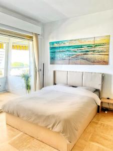 sypialnia z dużym łóżkiem i obrazem na ścianie w obiekcie #41 MARINA RIVIERA BAY - Marine Baie des Anges - Studio vue Mer et Port w mieście Villeneuve-Loubet