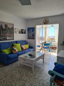 ein Wohnzimmer mit einem blauen Sofa und einem Tisch in der Unterkunft EEB Room HABITACIÓN PRIVADA EN PISO COMPARTIDO in La Laguna