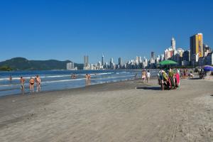 un groupe de personnes sur une plage près de l'eau dans l'établissement Em frente à praia em Balneário, 6 hóspedes VU3572, à Balneário Camboriú