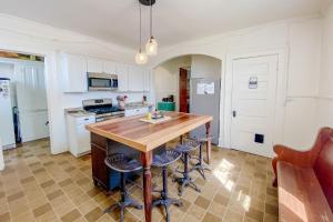 una cocina con mesa de madera y taburetes de bar en The Blacker House, en Manistee