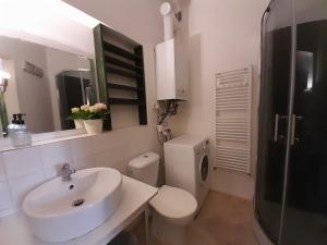 a white bathroom with a sink and a toilet at Apartmán Nad náměstím in Liberec