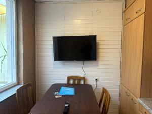 einen Tisch mit Stühlen und einen TV an der Wand in der Unterkunft L8 Street - Niefern-Öschelbronn in Niefern-Öschelbronn