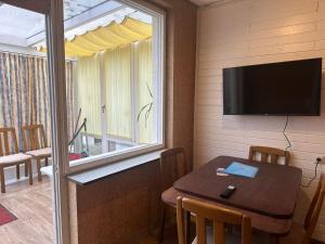 Zimmer mit einem Tisch, einem Fenster und einem TV in der Unterkunft L8 Street - Niefern-Öschelbronn in Niefern-Öschelbronn