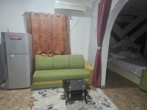 een woonkamer met een groene stoel en een bed bij apartment B1-9 in Muscat