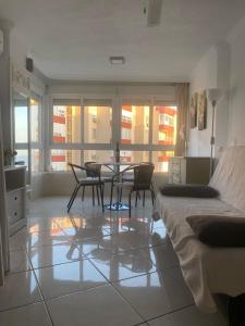 a bedroom with a table and chairs and a bed at Apartamento frente al mar in Torrox Costa