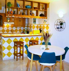 eine Küche mit einem weißen Tisch und blauen Stühlen in der Unterkunft Appartement cosy près de Paris. in Livry-Gargan