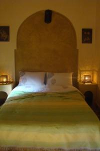 1 dormitorio con 1 cama grande y cabecero grande en Riad Menthe Et Citron, en Meknès