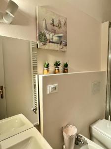 a bathroom with a sink and a toilet and a painting at Chez Amèlie in La Spezia +49 photos