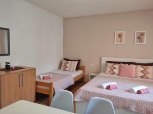 um quarto com duas camas e uma mesa e cadeiras em Apartment Polkaposki Trpejca em Trpejca