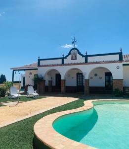 une maison avec une piscine en face de celle-ci dans l'établissement Los Alcores , disfruta de la naturaleza !, à Villalba del Alcor