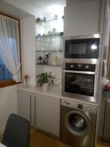 a kitchen with a microwave and a washing machine at Céntrica, espaciosa y cómoda in Getaria