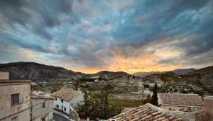 uma vista para uma cidade com edifícios e um pôr-do-sol em Casa Rural El Alcázar - Cehegín em Cehegín
