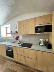 eine Küche mit Holzschränken und einer Arbeitsplatte in der Unterkunft La MaiZon du Bois Rez-de-Chaussée in Champagny-en-Vanoise