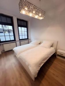 2 Betten in einem weißen Zimmer mit 2 Fenstern in der Unterkunft Wohngut-City Appartement 3 für max 5 Personen inklusive Parkplatz in Hagen