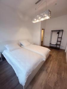 a bedroom with a large bed with white sheets at Wohngut-City Appartement 3 für max 5 Personen inklusive Parkplatz in Hagen