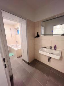ein Badezimmer mit einem Waschbecken und einer Badewanne in der Unterkunft Wohngut-City Appartement 3 für max 5 Personen inklusive Parkplatz in Hagen
