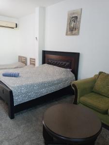 a bedroom with a bed and a couch and a table at Flower 2 in Jerash