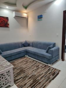 جوهرة الاماكن في تيماء: غرفة معيشة مع أريكة زرقاء وسجادة