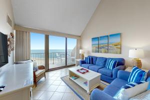 a living room with a blue couch and a balcony at Sea Colony Chesapeake House IV in Bethany Beach