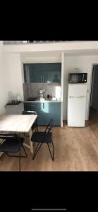 uma cozinha com uma mesa e um frigorífico branco em Studio Saint Cyr sur mer em Saint-Cyr-sur-Mer