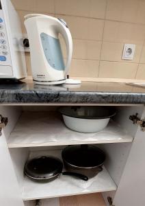 a kitchen shelf with a coffee maker and pans at Apartment in street Togolok Moldo 3 A in Bishkek +20 photos