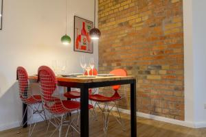mesa de comedor con sillas rojas y pared de ladrillo en Business-Apartment, en Leipzig