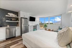 a bedroom with a bed and a kitchen with a refrigerator at Top of the Gulf 410 - Beach Front Resort Condo - RENOVATED LIKE NEW in Panama City Beach
